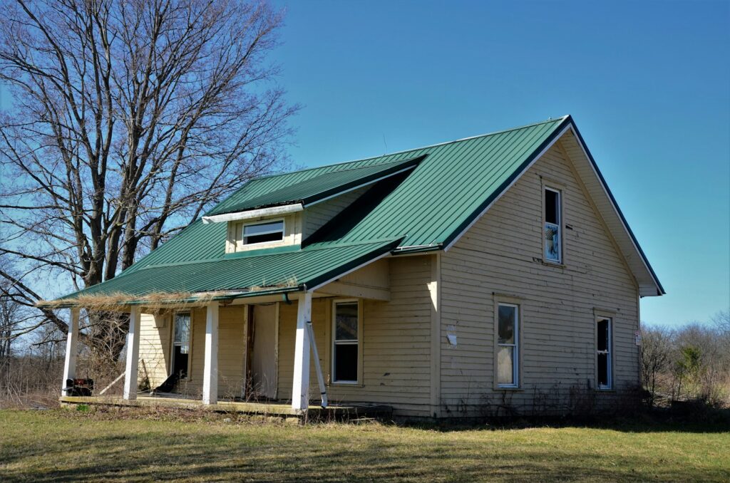 white and blue wooden house near bare trees under blue sky during daytime
